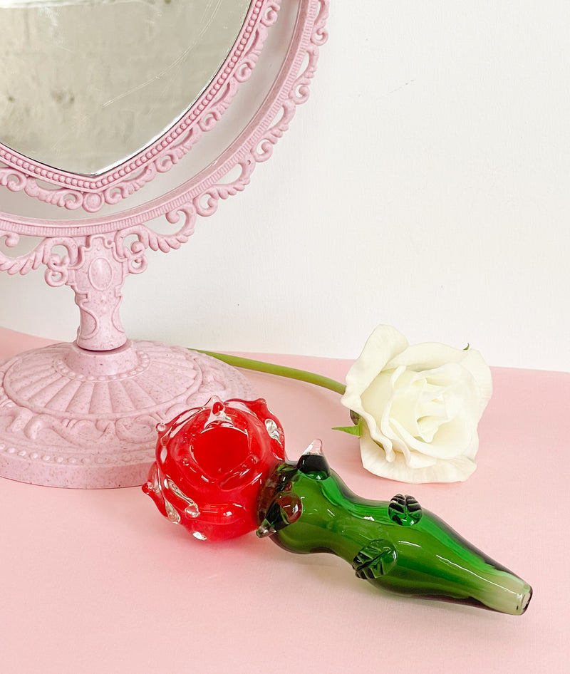 GLASS ROSE PIPE SITTING ON A TABLE